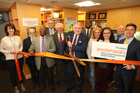 legislators easterseals staff and other officials cutting ribbon in milford wellness village room