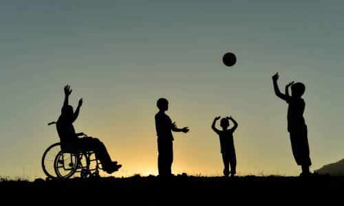 a silhouette of 4 people playing basketball, one of them uses a wheelchair.