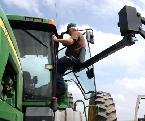 Man getting lifted into tractor