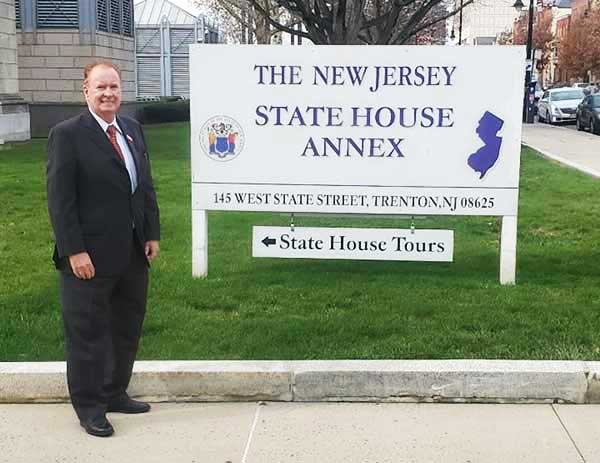 Brian Fitzgerald standing next to the New Jersey State House Annex sign