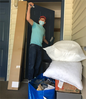 Excited veteran, raising his arm in the air triumphantly, as he moves his things into his new apartment.