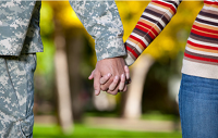 Caregiver and military veteran holding hands