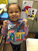 Girl from CDC holding bag of donated CVS school supplies