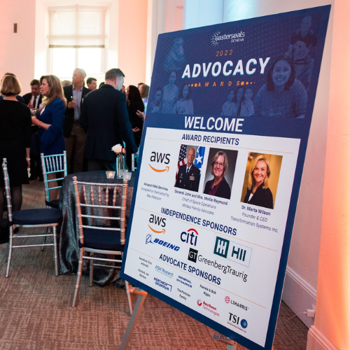 Sign on an easel in the entryway of a room listing award recipients and sponsors.