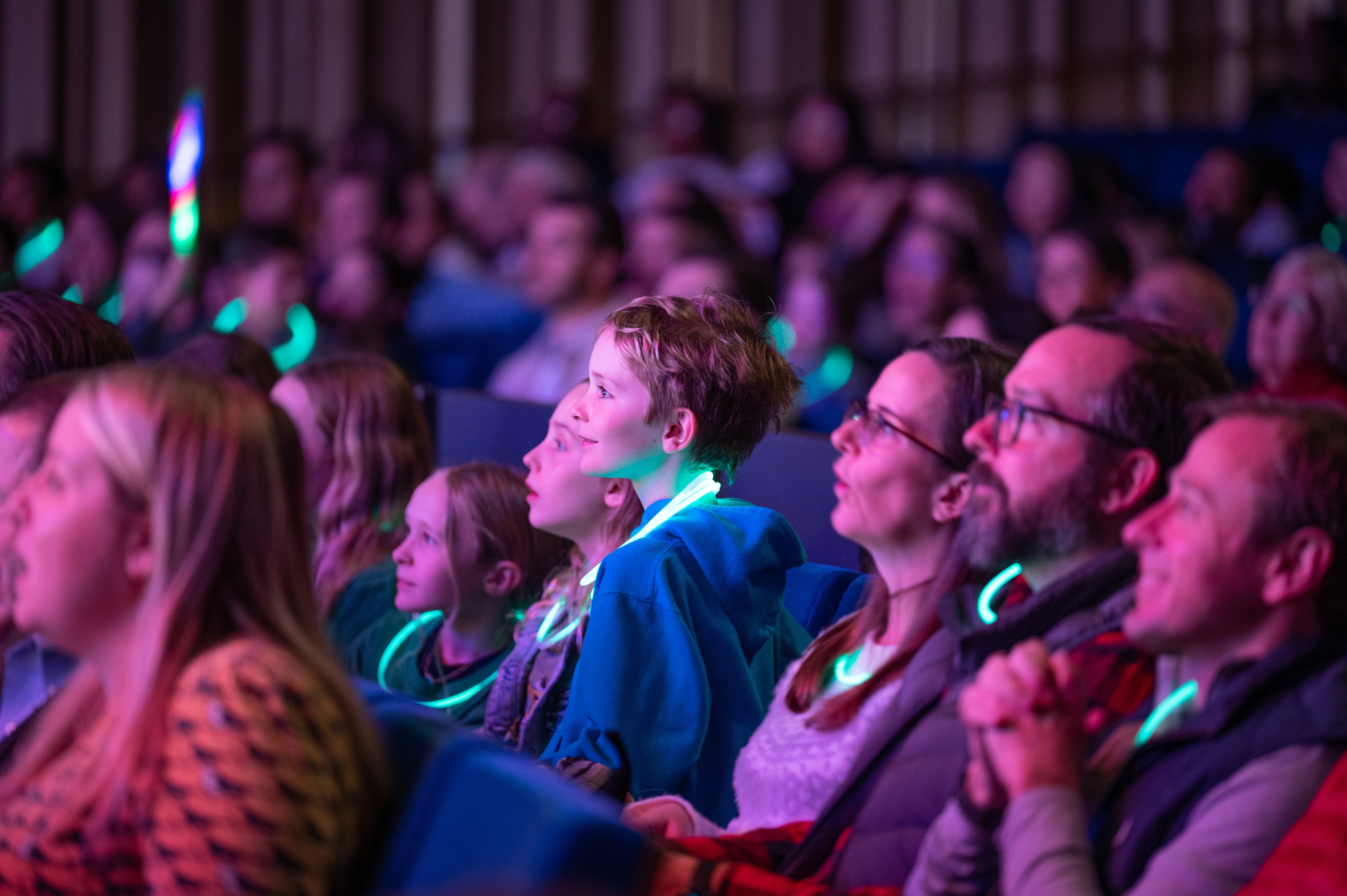 Families in the audience smiling and enjoy the Omnium Circus performance.