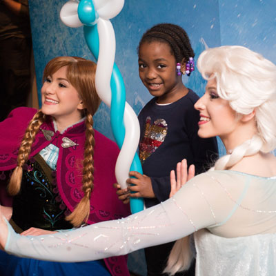 child poses with Disney Princesses
