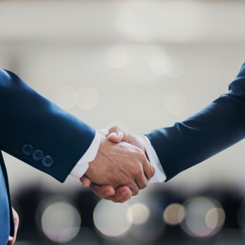 Two people in business suits shaking hands