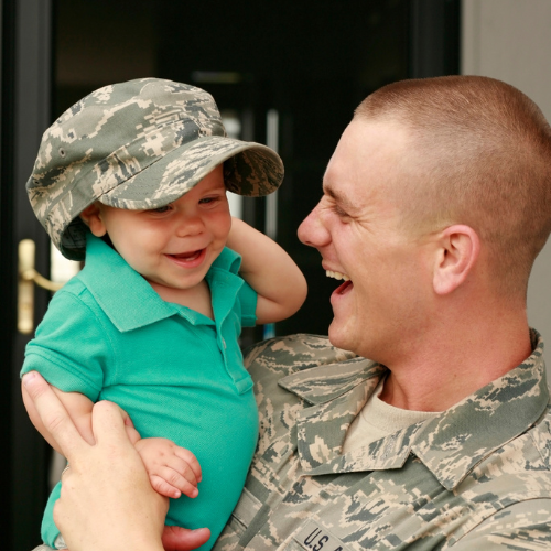Veteran smiling and holding up his son