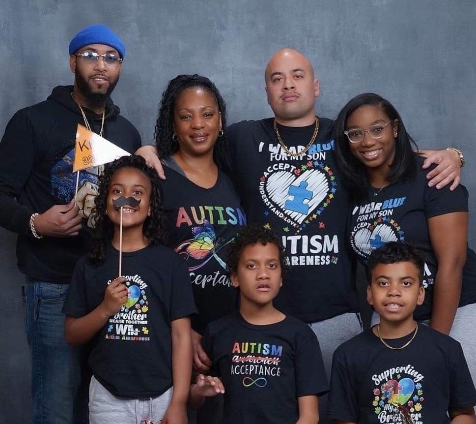 Grant family wearing a variety shirts promoting autism acceptance.