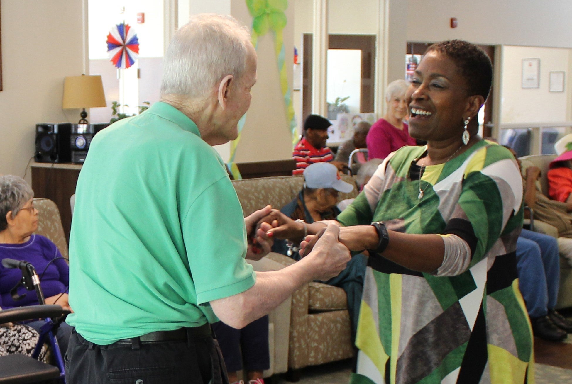 Female staff member guides a walking senior.