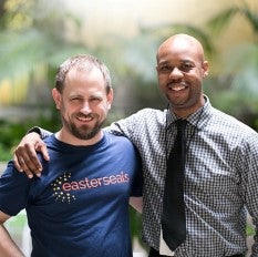 man in Easterseals t-shirt next to man in tie both smiling.