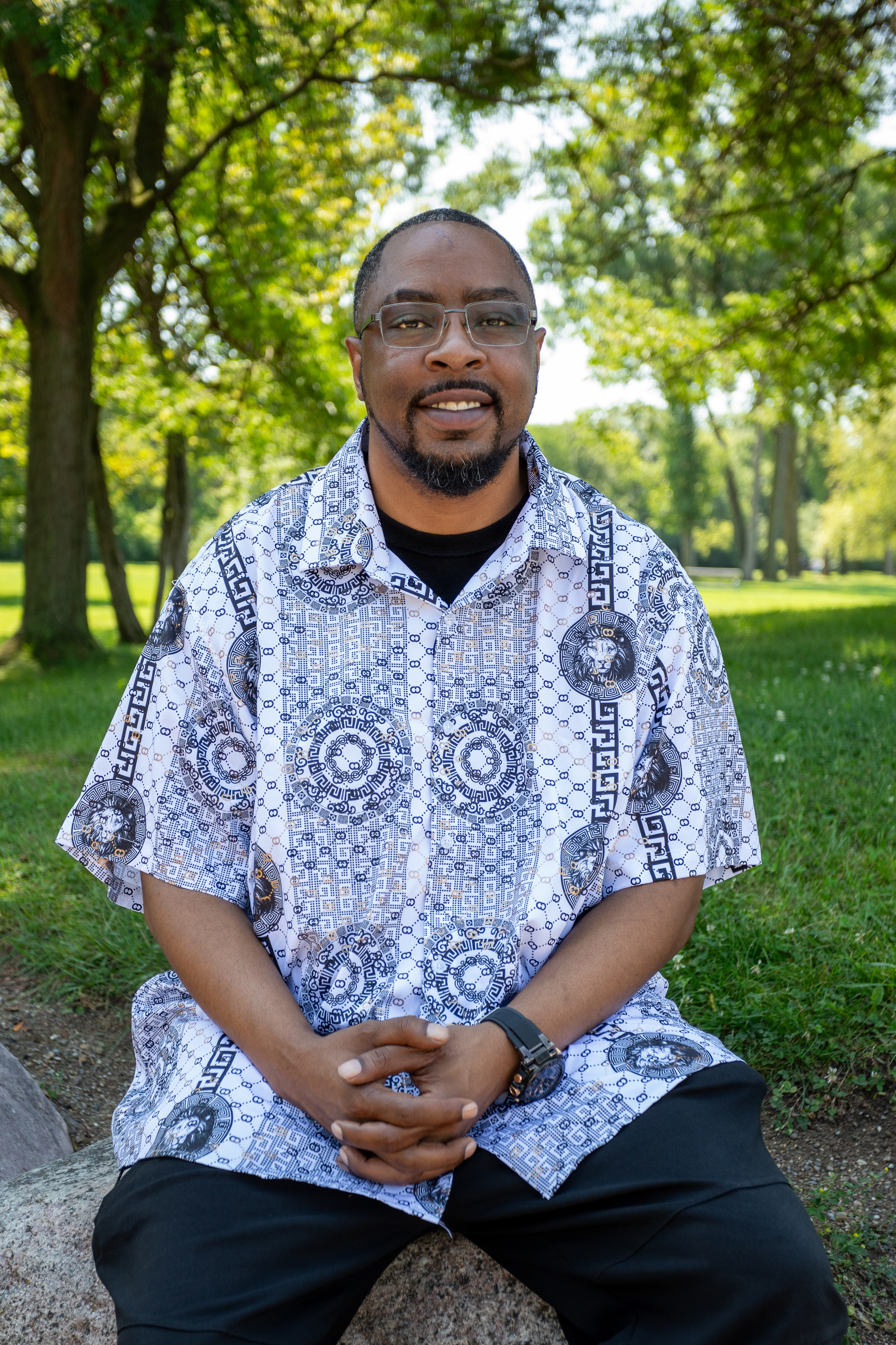 image of adult male sitting with a black and white shirt