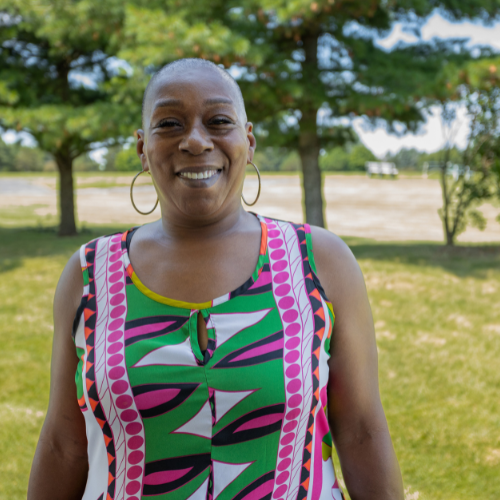 image of woman, Juanita, smiling and wearing a bright colored tank top