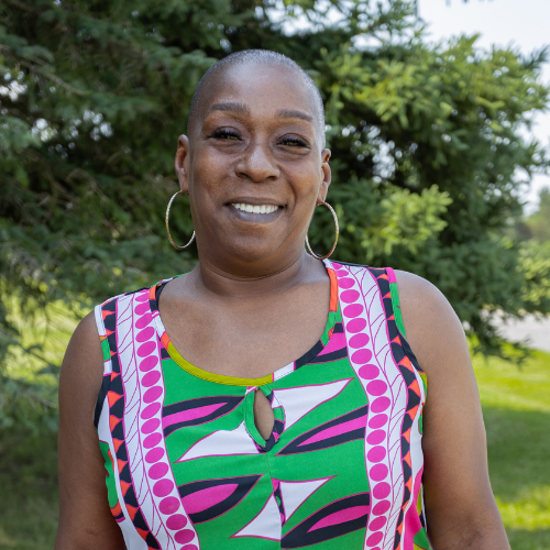 image of woman, Juanita, smiling and wearing a bright colored tank top