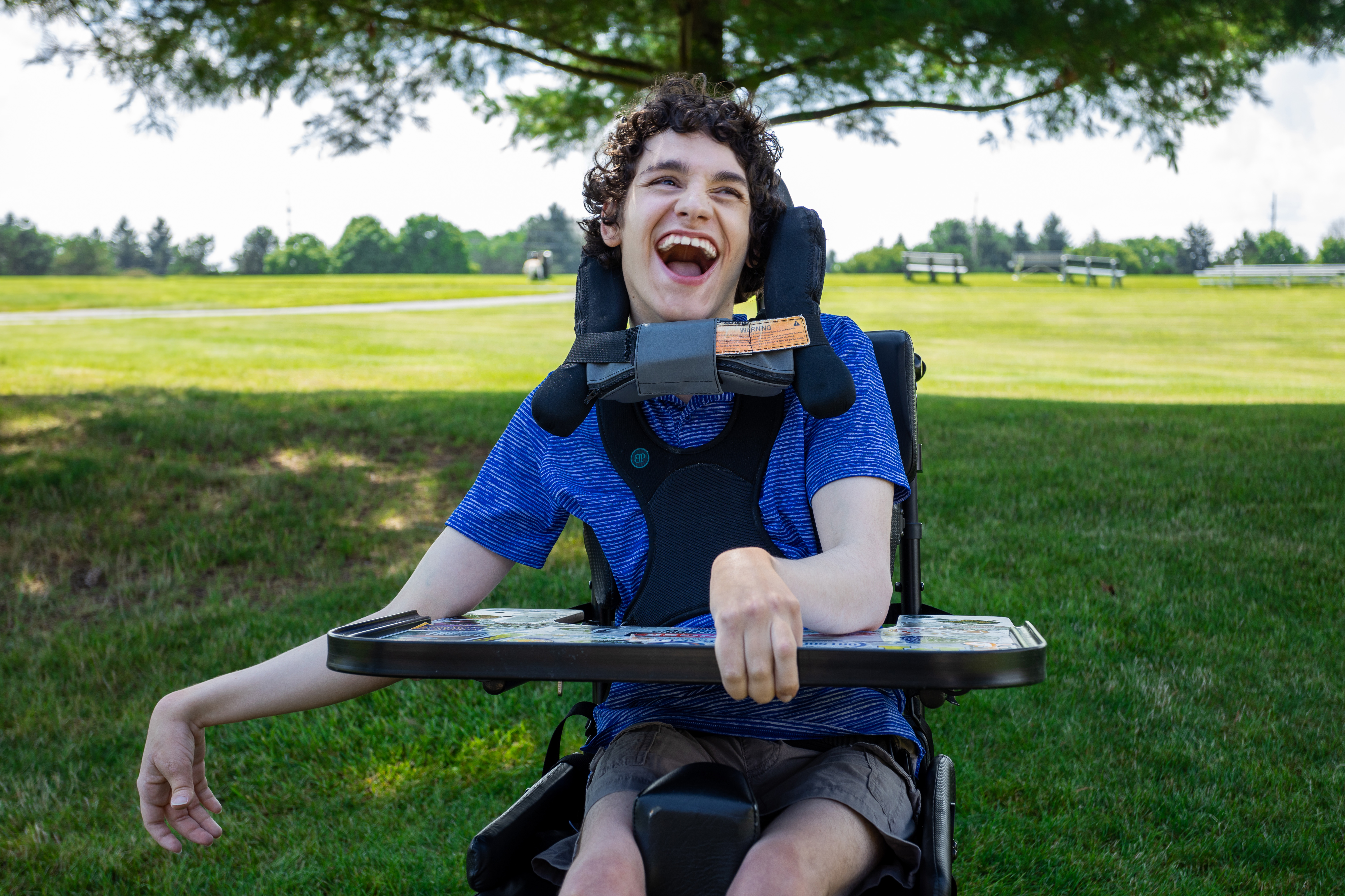 Photo of young man, Zander, laughing at the park