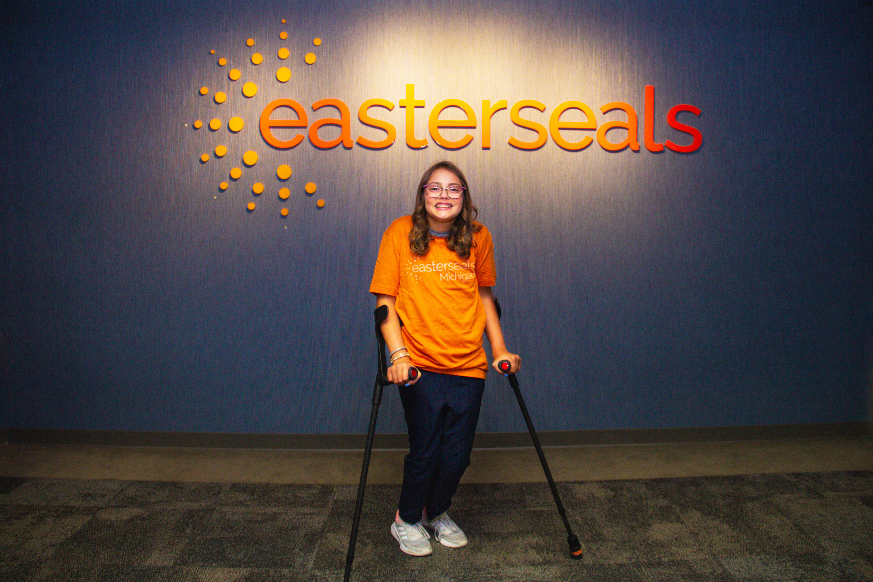 Allison with orange shirt - easterseals logo behind