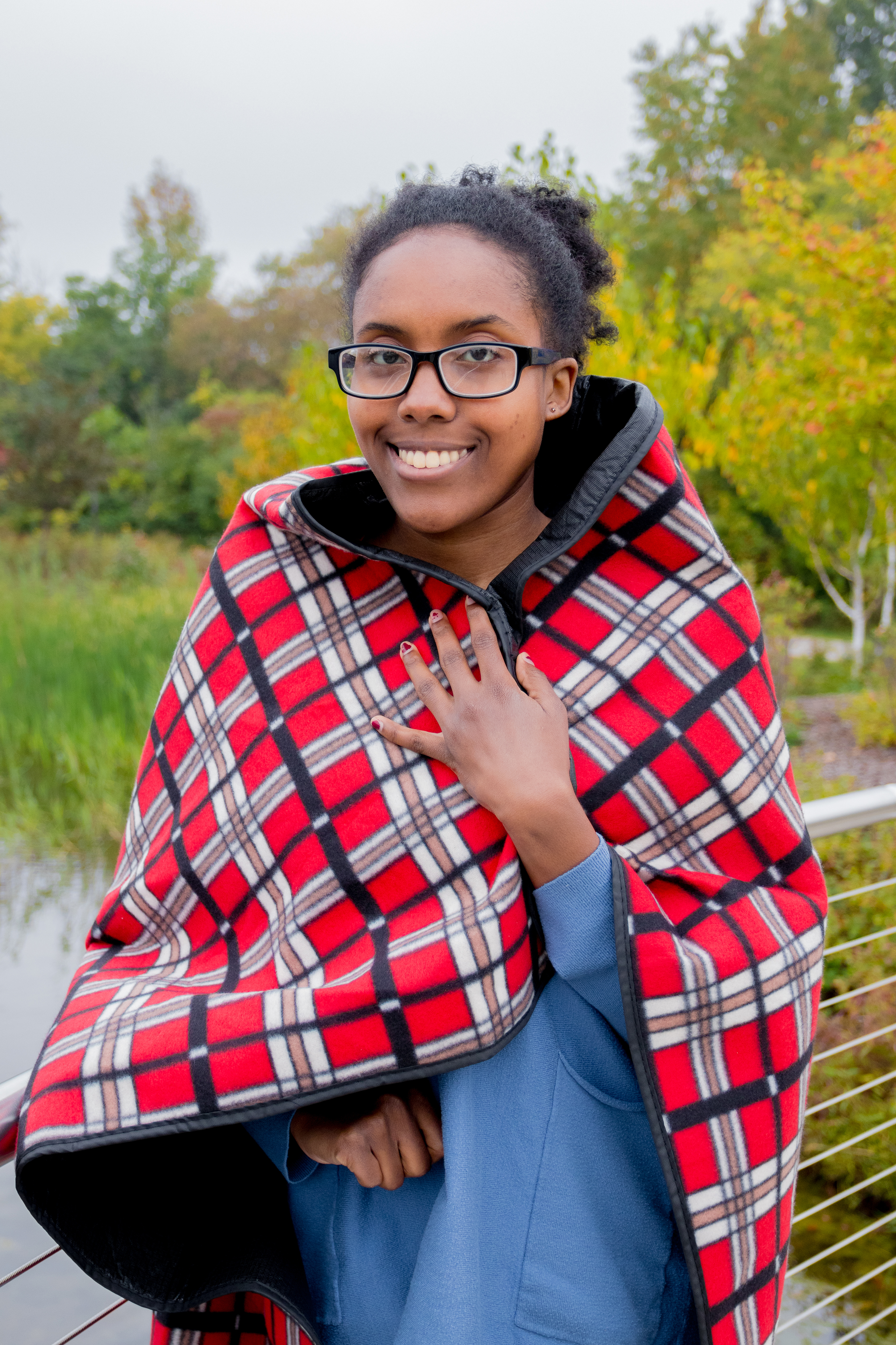 Jai Lynn posing for camera with a blue shirt and red blanket drapped around her shoulders