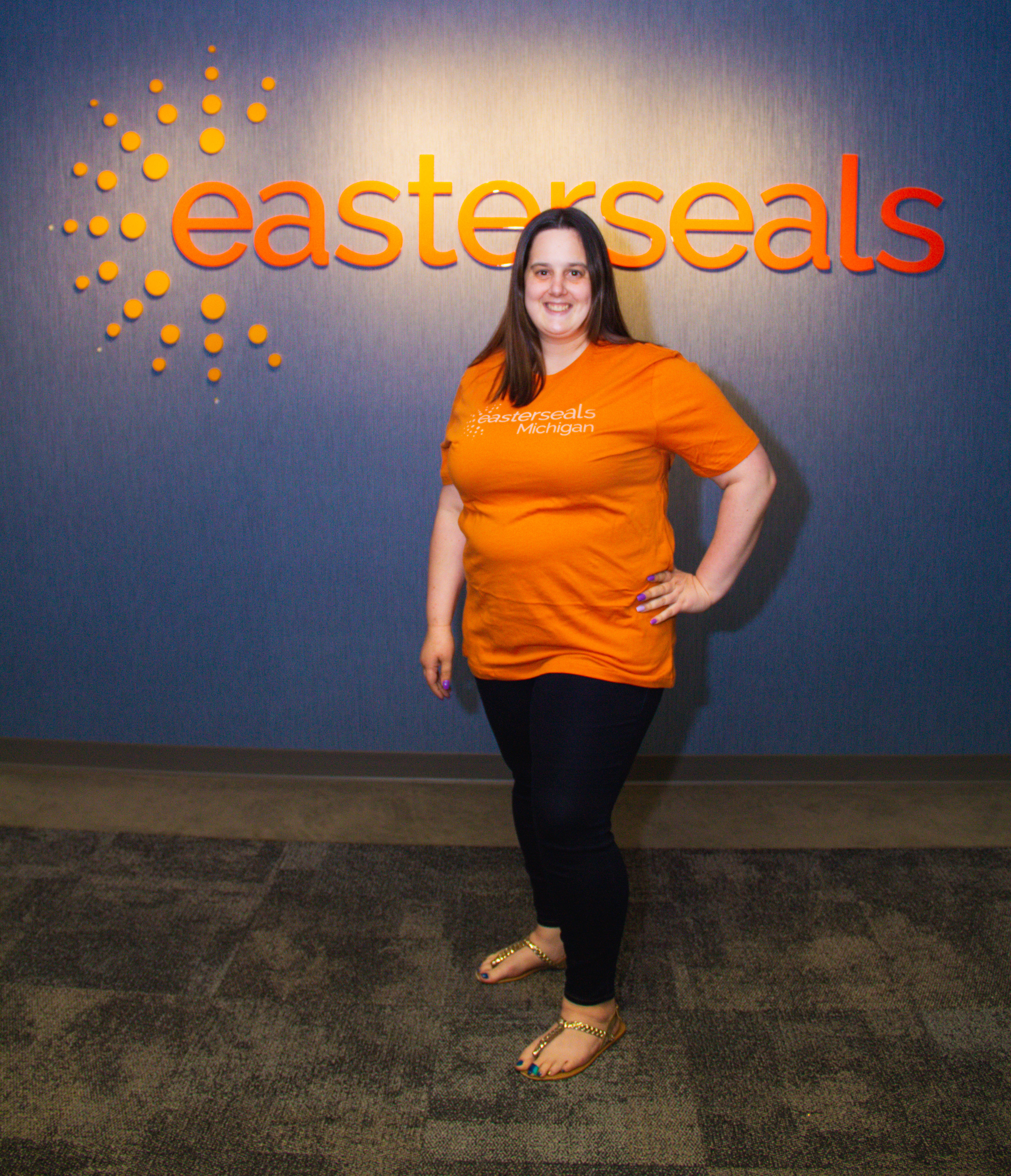 sarah posing with the easterseals logo in the background