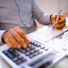 a photo of a man working with a calculator and paper