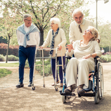 a group of four older men and women take a stroll outside