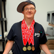 Ryan S posing with his three medals from swimming