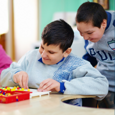 two kids at a table playing with a board game