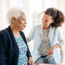 an older woman using a walker is talking to a young woman