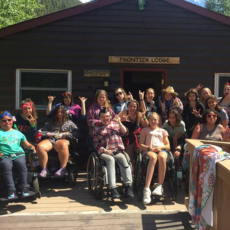 group photo in front of Frontier Lodge at RMV