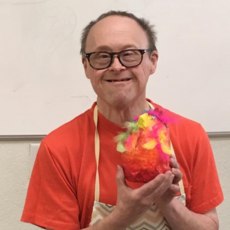 a man in a red shirt holding an art project 