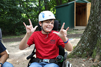 A child camper with a helmet on getting ready to go on a zipline