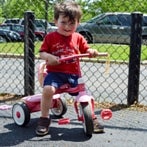 Boy on Bike in Lily Garden