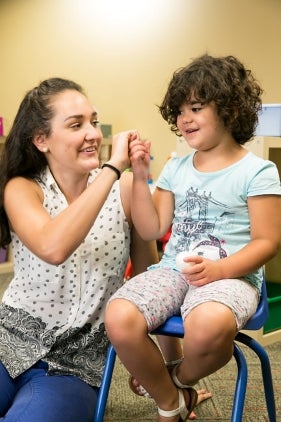 Girl in chair with therapist - small size