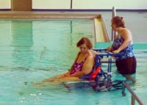 Pool staff uses an aquatic wheelchair to assist clients with disabilities.
