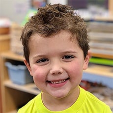 Declan Chavis square close-up with yellow shirt and big smile