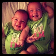 two little babies wearing matching onesies laughing at the camera