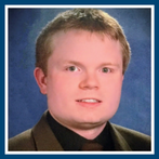 portrait of young man smiling with reddish hair and a shirt and tie on.