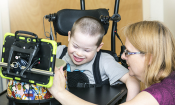 A young boy uses assistive technology at school