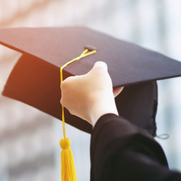 zoomed in photo of a female hand holding up graduation cap