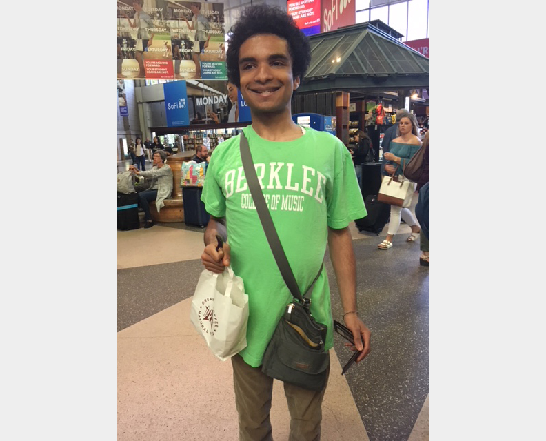 Adam smiling wearing a green Berklee College of Music tee shirt
