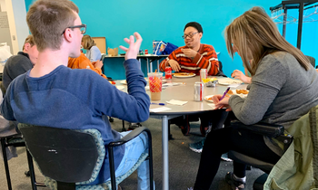 a group of teens gather for Youth Leadership Network and eat snacks at a table