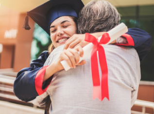 A female college graduate hugs someone with a diploma in her hand