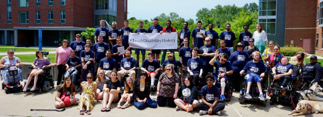 group of people wearing matching T-shirts, holding a sign that reads "TeachDisabilityHistory" as part of Youth Leadership Network initiative