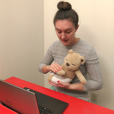 Shannon, a Rehabilitation Therapist, demonstrates for a client using a laptop