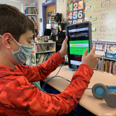 Joey uses a tablet as Assistive Technology to participate in class.