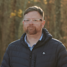 headshot of Dave outside in a wooded area