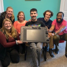 alexander freeman and the ESMA AT team hold a large device that he uses to control computers