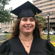 Caterina smiles wearing her graduation cap