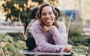 allison thompkins smiles for a headshot in her wheelchair outside