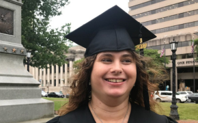 Caterina smiles wearing her graduation cap
