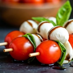 close up of skewer with tomato, mozzarella, and basil